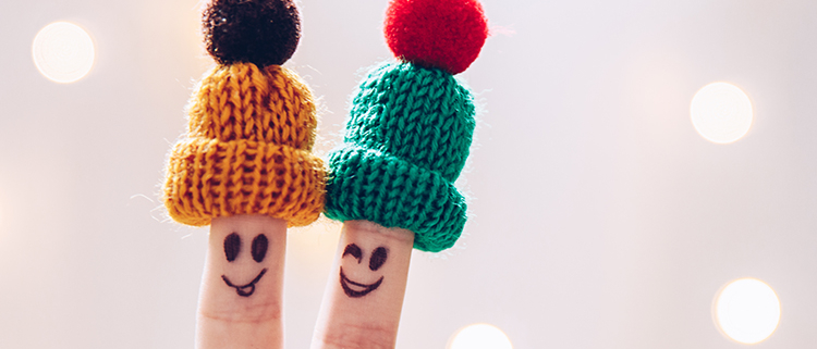 Reducing Stress Funny couple fingers on knitted winter warm hats smiling and wink